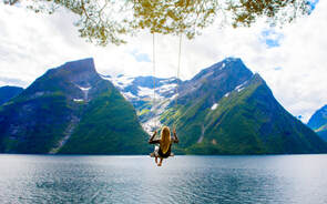 Girl on swing over water